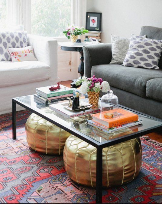 a black frame glass coffee table will fit a modern space and you can store your poufs under it