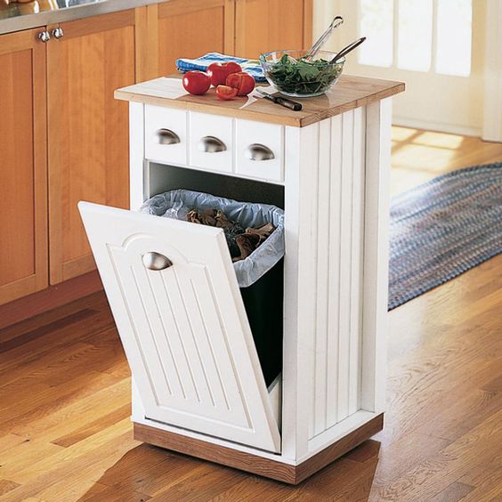 a tiny kitchen island with a tilt out trash can inside