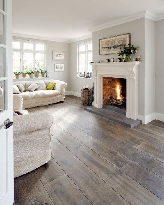 a white living room with grey and brown stained wooden floors, textural upholstery also adds to the space