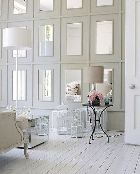 repeated mirrors in large white frames on the wall make the shabby chic space a bit more modern