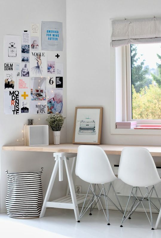 a Scandinavian workspace for two with a long trestle desk on white legs, which is used instead of a windowsill