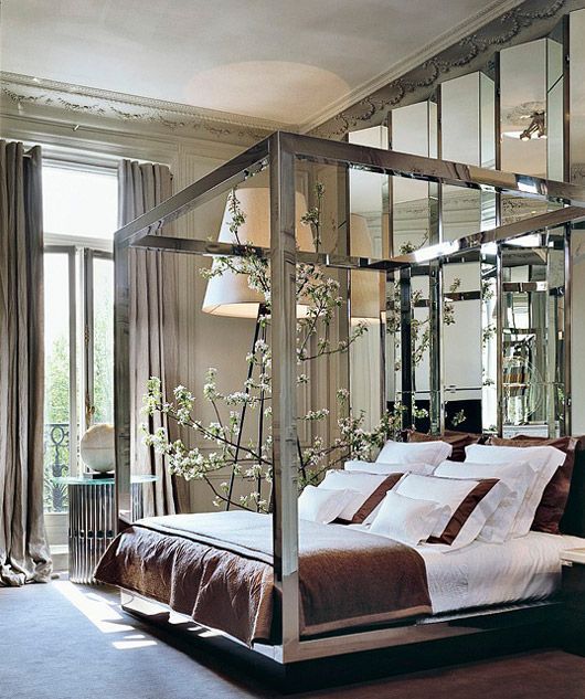 a geo mirror wall and a mirror bed frame add interest to the bedroom