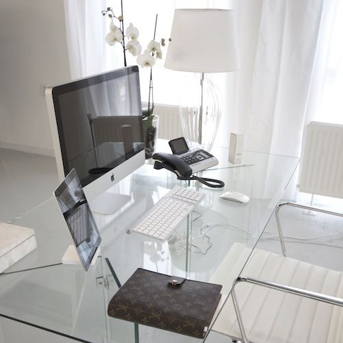 A modern all white home office in white with a clear all glass desk for an airy feel
