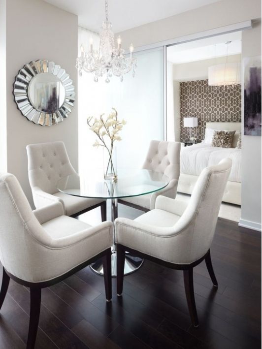 glam timeless dining area with dark wooden floors and matching chairs with white upholstery