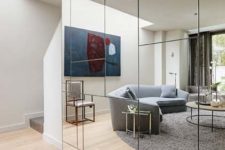19 a geometric mirror wall visually doubles the living room and it looks much bigger