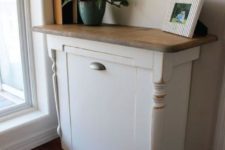 19 vintage-inspired white cabinet with a rustic top and a tilt out trash can