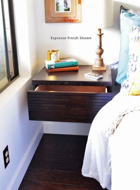 a dark stained floating nightstand with a large drawer
