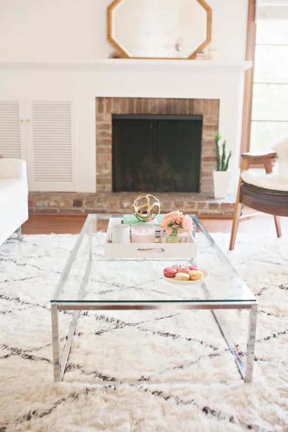 a low coffee table on nickel legs with a glass tabletop can fit a modern or even a boho space
