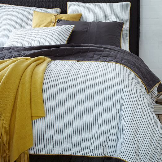 blue thin striped bedding with black and mustard touches for a bolder look