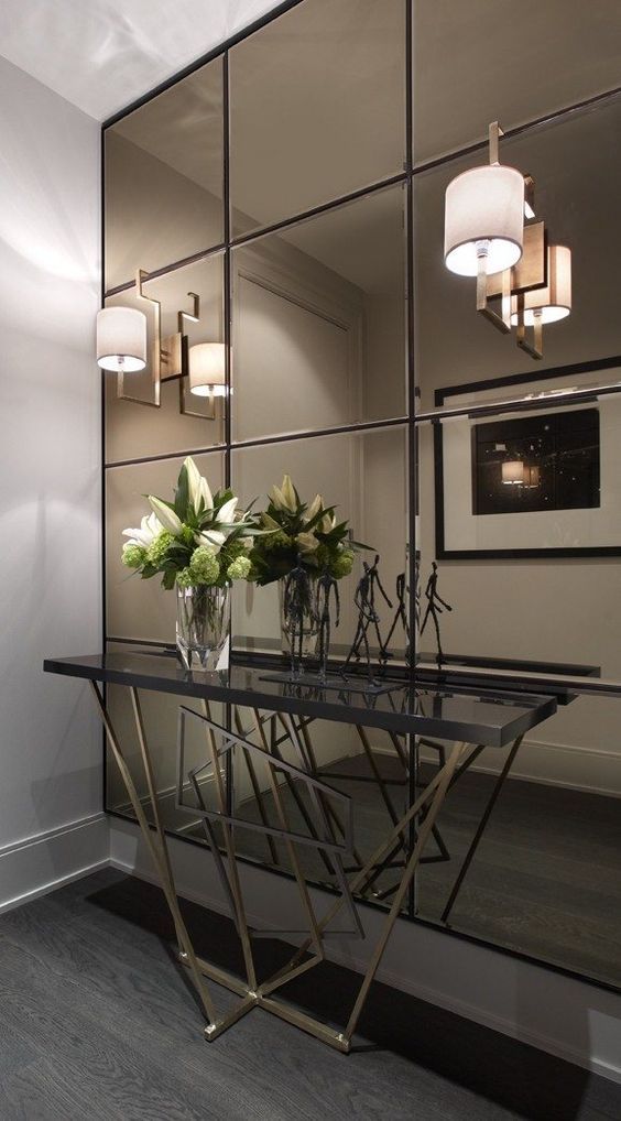 a smoked mirror wall, a geo base console make this entryway super modern and eye-catchy
