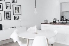 23 a united kitchen and dining space with a black and white gallery wall, which adds style