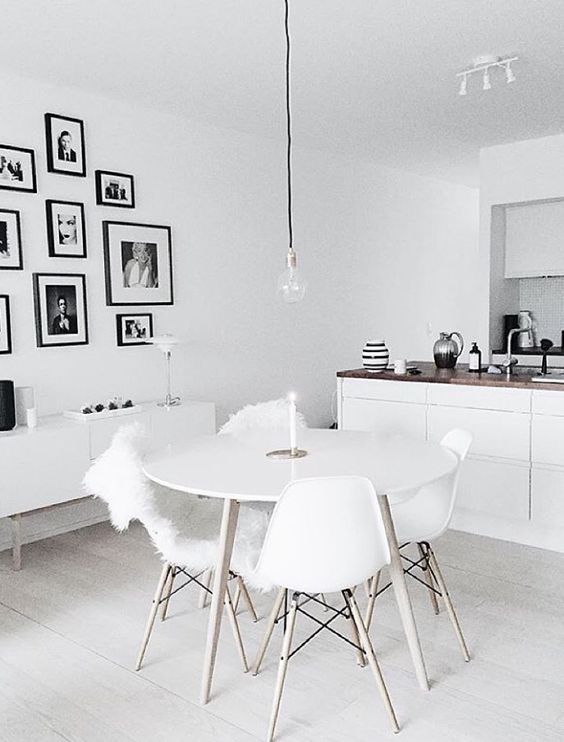 a united kitchen and dining space with a black and white gallery wall, which adds style