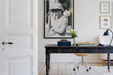 24 a large black antique desk stands out in an all-white space