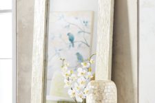 24 a large mother of pearl mirror and a couple of vases clad with the same material look very feminine and eye-catching