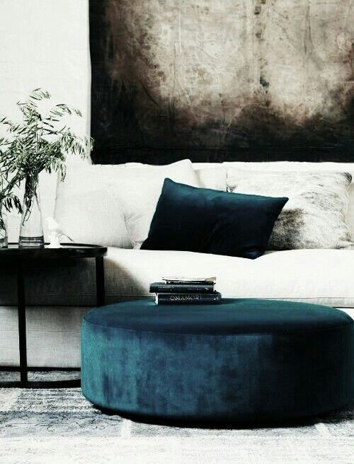a navy ottoman and a pillow won't break the bank but will make your space fashionable and luxurious