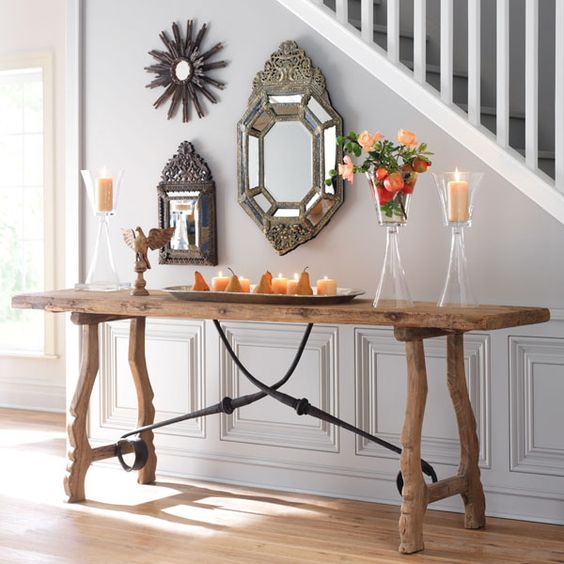 a rustic trestle console table with blackened metal decor echoes with vintage metal framed mirrors
