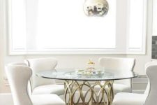 25 a glam dining space with metallic sphere pendant lamps, a brass table base and a round tabletop, comfy cream chairs