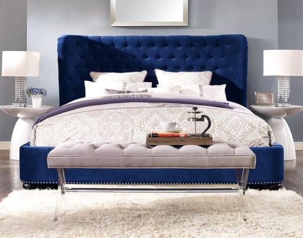 a navy velvet upholstered sofa makes a bold statement in a neutral bedroom