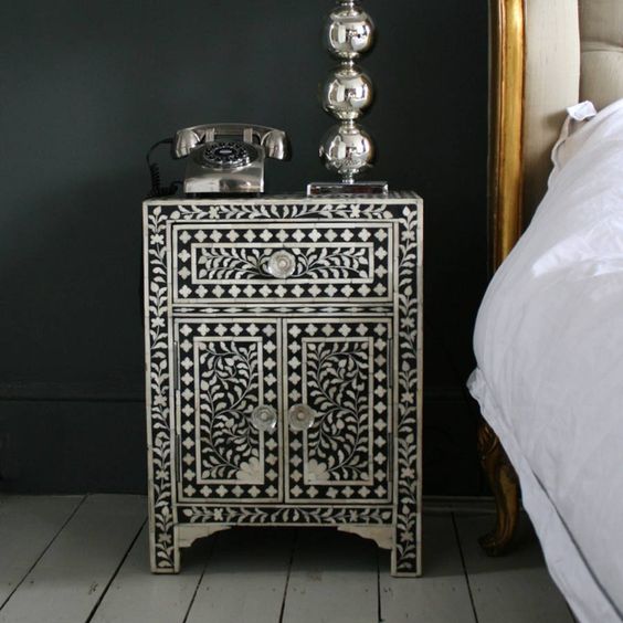 a refined black nightstand clad with mother of pearl looks vintage and very refined