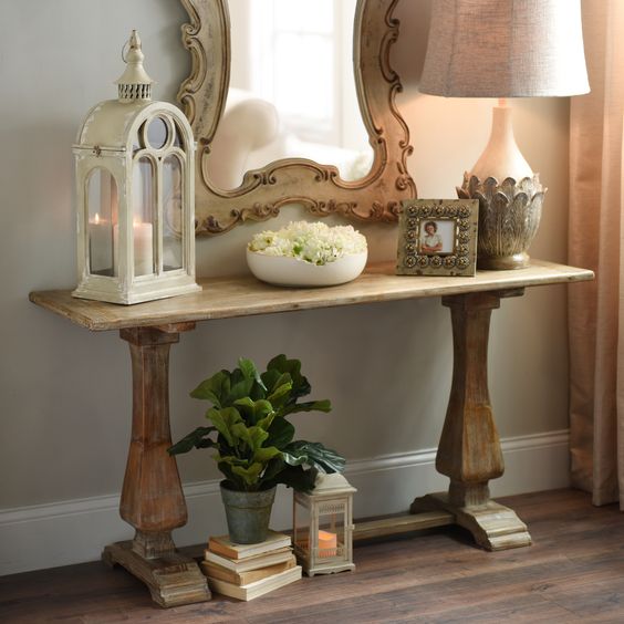 a small trestle table used as a console for a vintage-inspired entryway