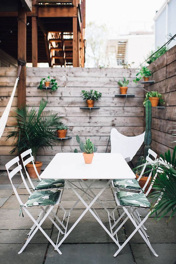 palm leaf print chairs echo with cacti and greenery and cheer up this outdoor space