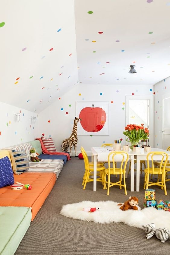 a super bold space with floor cushions along the wall and colorful polka dots looks awesome