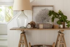 28 a wooden trestle table used in an entryway or living room as a console, a basket for additional storage