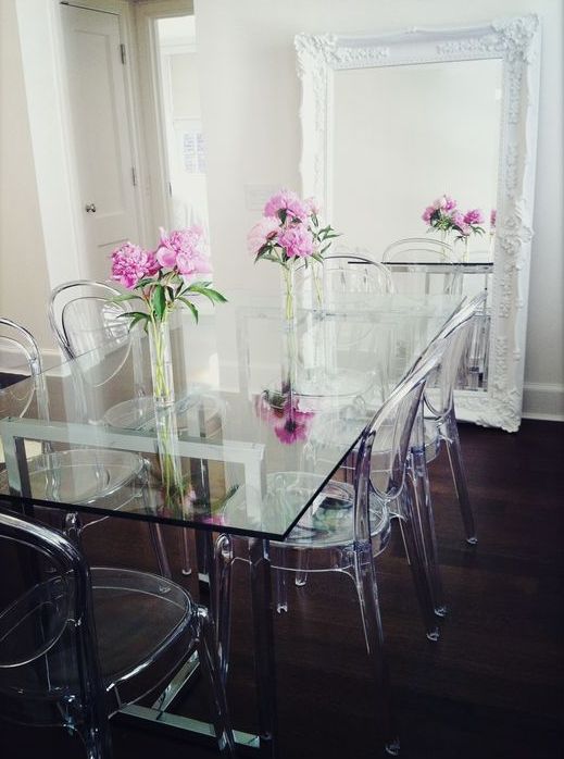 A vintage dining room is made more eye catching with an ultra modern glass top dining table and acrylic chairs