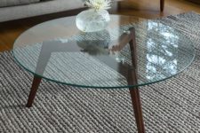 29 mid-century modern coffee table with dark stained wooden legs and a round glass top