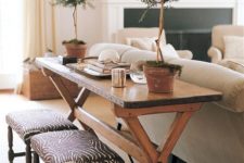 29 rustic wooden trestle table is repurposed into a console that adds warmth to this living room