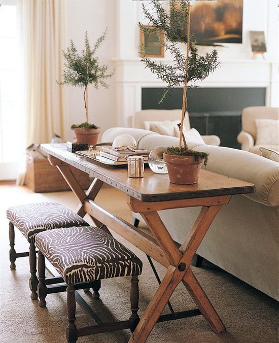 rustic wooden trestle table is repurposed into a console that adds warmth to this living room