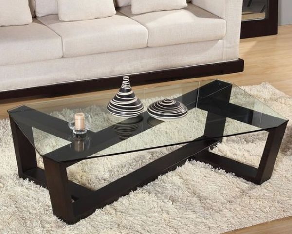 ultra-modern coffee table with a sculptural dark stained wooden base and a glass tabletop