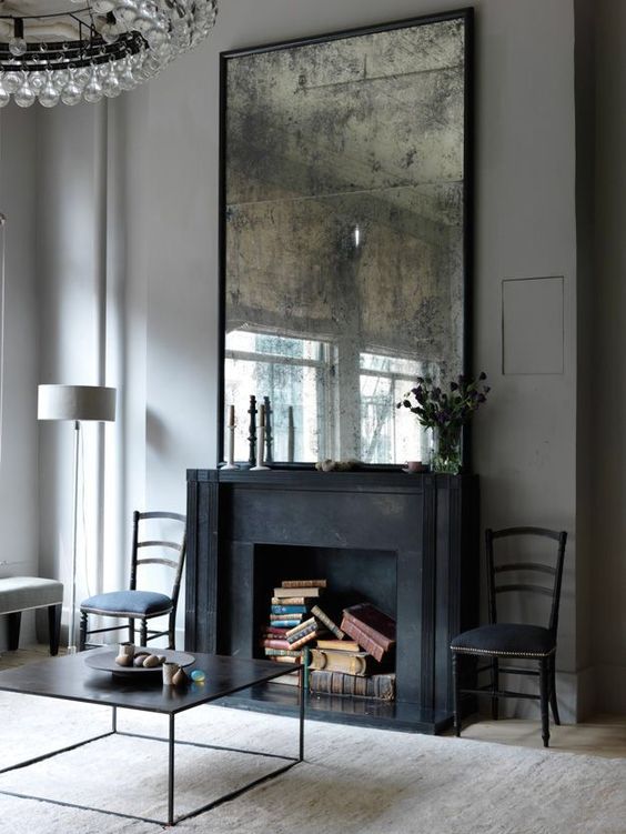 a black fireplace is repurposed into a book storage space