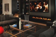 02 a modern man cave with sofas, coffee tables, a fireplace and a large TV to watch sport