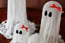 02 small cheesecloth ghosts with black eyes and red bows on top for a table arrangement