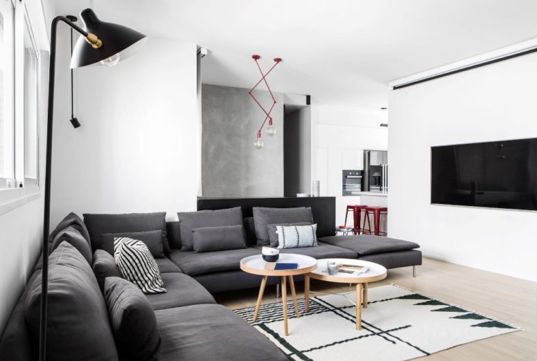 The living room features a large sectional grey sofa, a geo rug and eye-catchy red lights