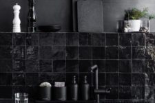 03 a bleached metal wall and a hand glazed glossy black tiles for a dark masculine kitchen
