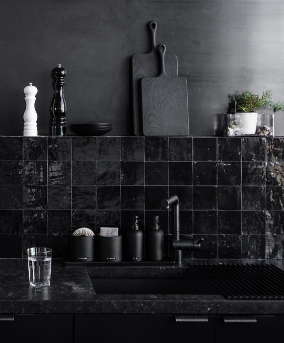a bleached metal wall and a hand glazed glossy black tiles for a dark masculine kitchen