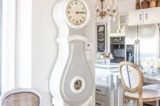 03 a shabby farmhouse kitchen and dining space with a grandfather’s clock in grey and white