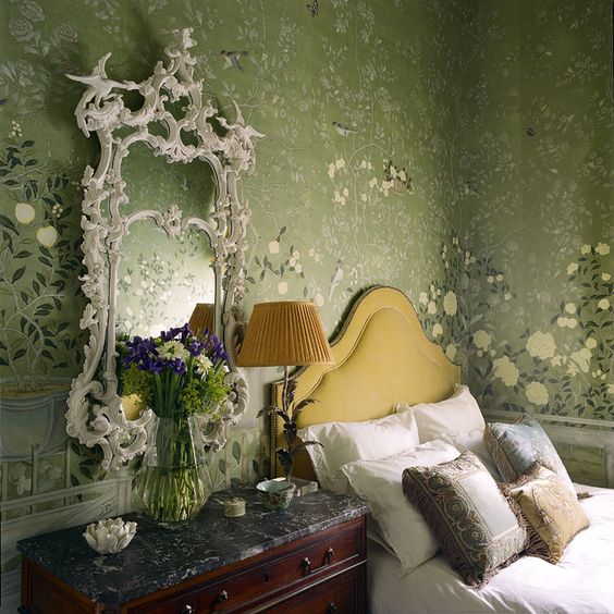 The guest room is luxurious with its 18th century mirror and an upholstered bed
