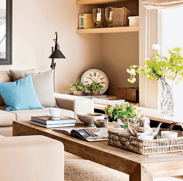 The living room is done in neutral beige tones, with a rustic wooden coffee table