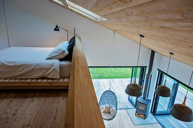 The master bedroom features a suspended bed, skylights on the sloping roof
