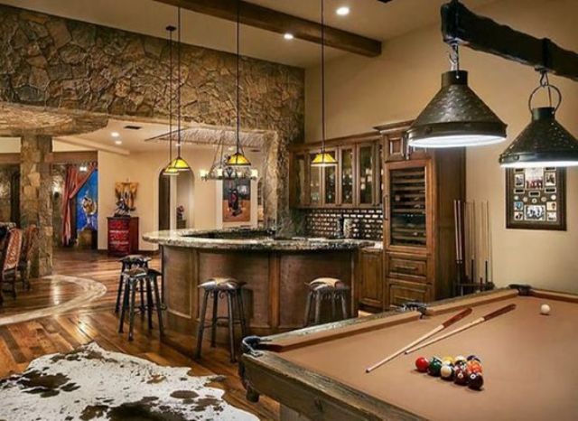 a man cave decorated in rustic style, with stone, wood and with faux animal skins
