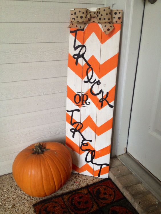 an orange and white chevron sign with black letters and a burlap bow
