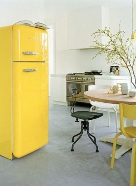 cheer up a neutral and peaceful kitchen with a sunny yellow Smeg fridge and a matching chair