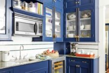 07 a bold blue kitchen with neutral countertops and brass handles for a vintage feel
