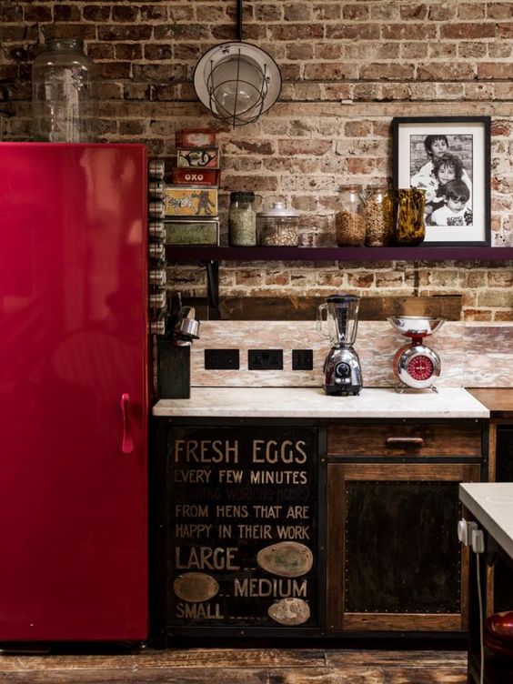 an industrial kitchen with a shiny red fridge to make a statement with color