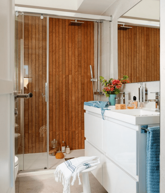 The mom's bathroom looks luxurious and modern, with a wood clad wall in the shower