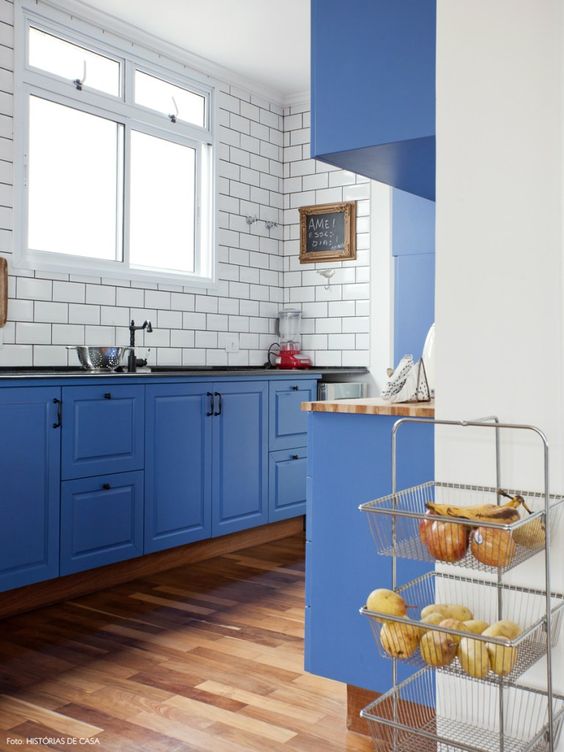 a bold blue kitchen with white subway tiles and black grout to stand out