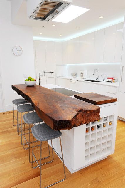 a bold kitchen countertop on a kitchen island with a piece of raw edge wood and wine storage